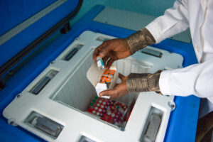 A nurse handles vaccines from a brand new solar fridge in a newly opened health centre in the village of Mbankana, some 150km from Kinshasa, in the Democratic Republic of the Congo. Healthcare facility electrification and solar fridges allow the vaccine cold chain to be maintained in even remote stations.